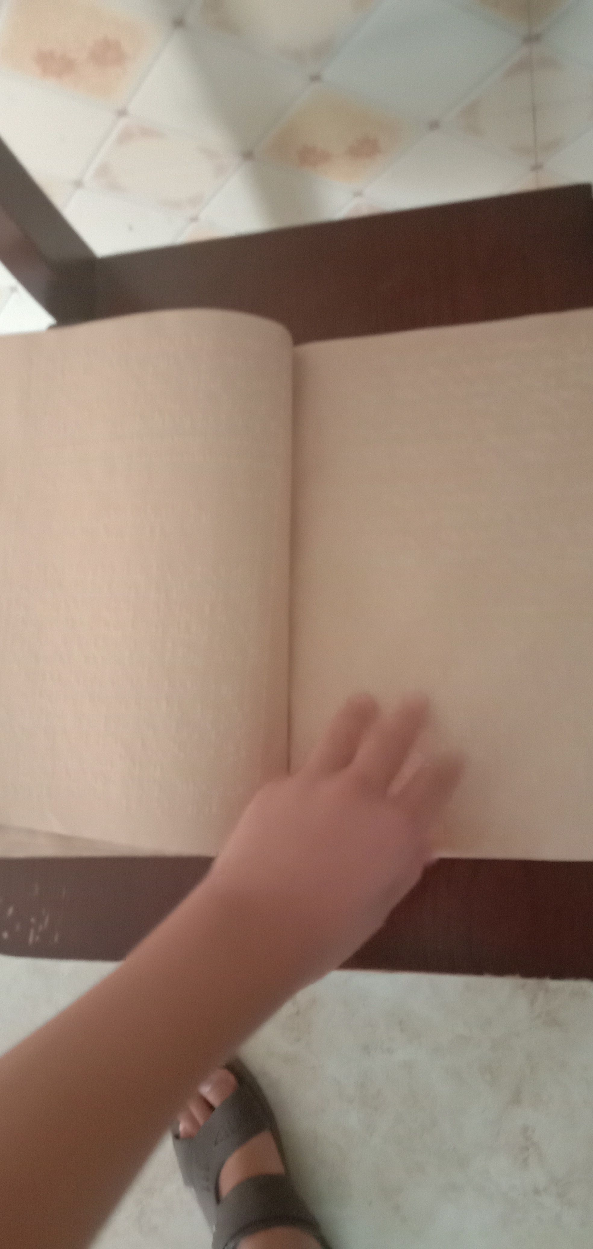 一本打开的盲文书一只手放在两页书的中间，准备翻动